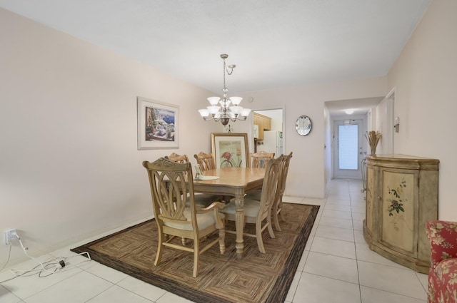 dining space featuring a chandelier, light tile patterned floors, and baseboards