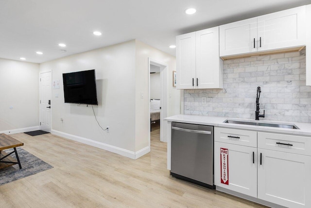 kitchen with light wood-style floors, dishwasher, light countertops, and a sink