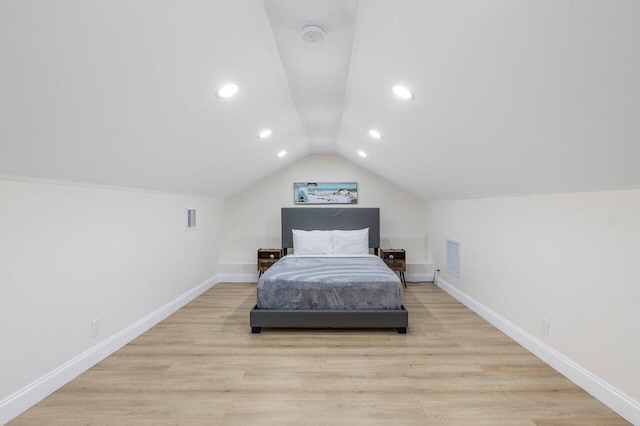bedroom with visible vents, baseboards, wood finished floors, and lofted ceiling