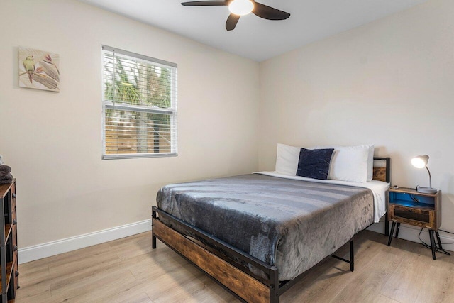 bedroom with light wood-style flooring, baseboards, and a ceiling fan