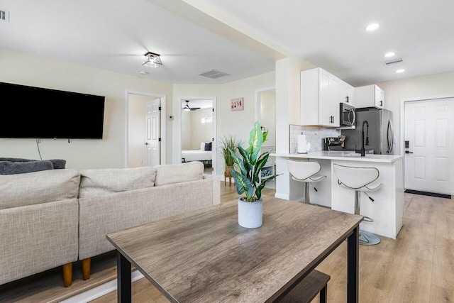 dining room with visible vents, light wood-type flooring, and recessed lighting