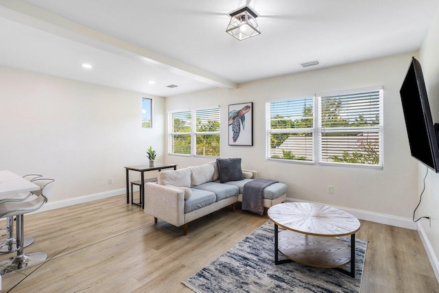living room featuring baseboards, recessed lighting, visible vents, beamed ceiling, and light wood finished floors