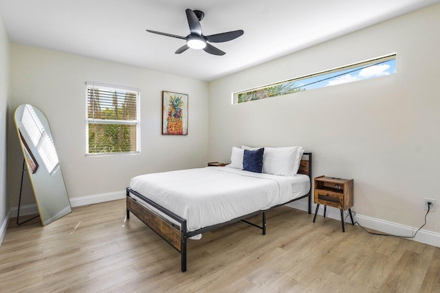 bedroom with light wood-style flooring, multiple windows, and baseboards
