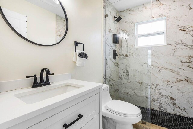 full bathroom with toilet, a stall shower, and vanity