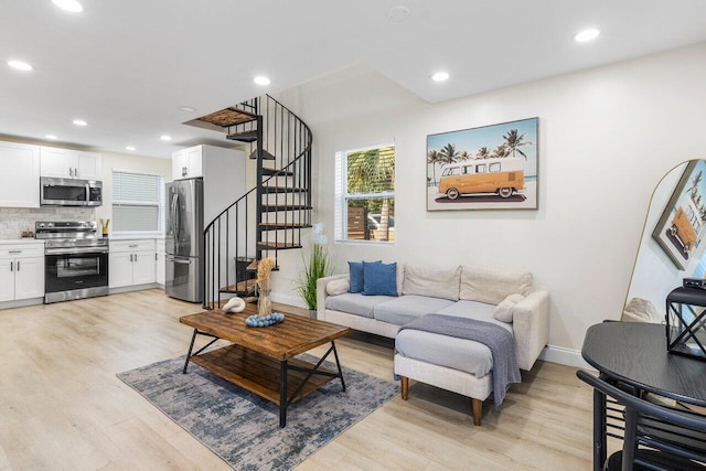 living area featuring recessed lighting, stairway, light wood-type flooring, and baseboards