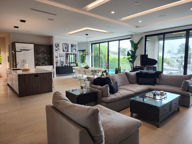 living area with light wood finished floors, visible vents, and recessed lighting