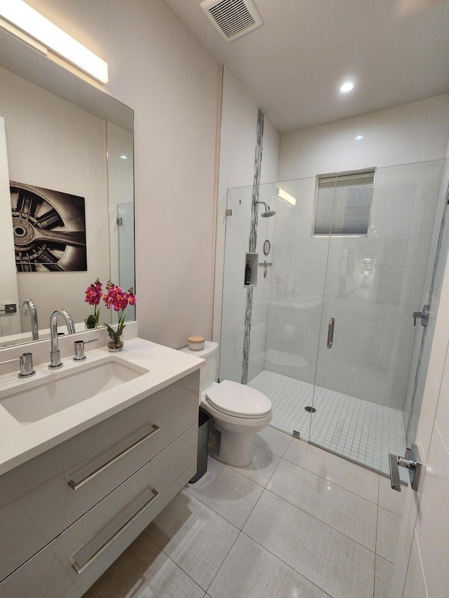 full bathroom with visible vents, toilet, a shower stall, vanity, and tile patterned floors