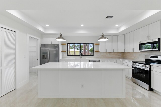 6002 Myrtle Dr, Fort Pierce, FL 34982 - kitchen featuring stainless steel appliances, open shelves, a tray ceiling, a center island, and decorative backsplash