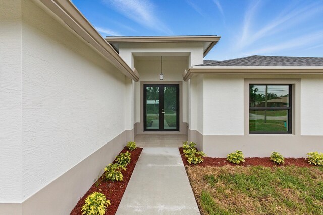 6002 Myrtle Dr, Fort Pierce, FL 34982 - entrance to property with french doors, a shingled roof, and stucco siding