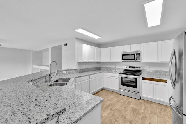 698 SW Mchole Ave, Port Saint Lucie, FL 34953 - kitchen with white cabinets, light stone counters, stainless steel appliances, and a sink