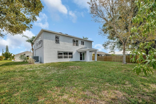 698 SW Mchole Ave, Port Saint Lucie, FL 34953 - rear view of house with cooling unit, a yard, stucco siding, and fence
