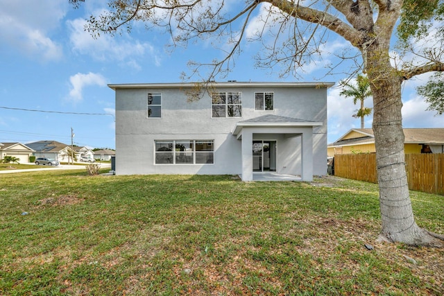 698 SW Mchole Ave, Port Saint Lucie, FL 34953 - back of property featuring stucco siding, a patio area, a lawn, and fence