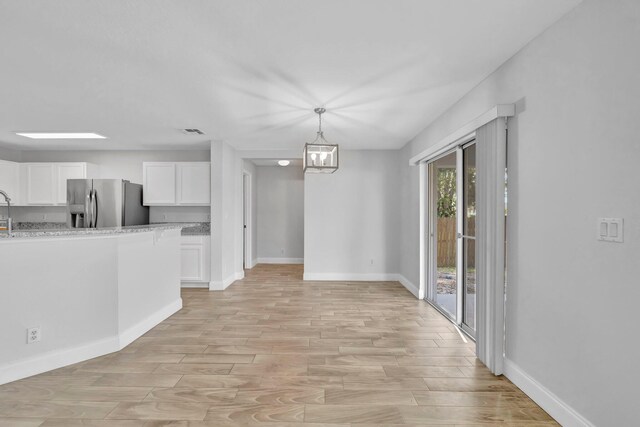 698 SW Mchole Ave, Port Saint Lucie, FL 34953 - unfurnished dining area featuring baseboards, light wood-style floors, visible vents, and a sink