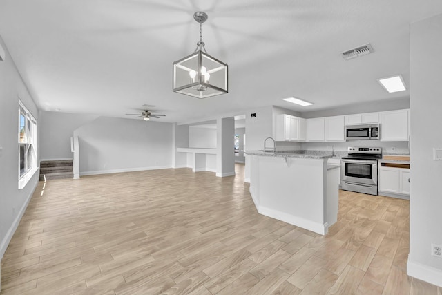 698 SW Mchole Ave, Port Saint Lucie, FL 34953 - kitchen featuring white cabinets, light wood-style flooring, baseboards, visible vents, and appliances with stainless steel finishes
