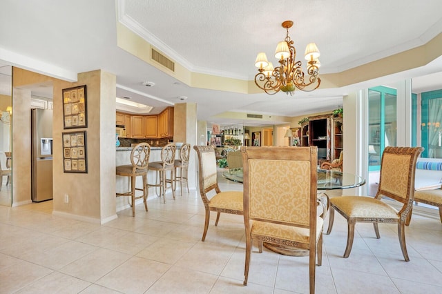 dining area featuring light tile patterned floors, a tray ceiling, ornamental molding, visible vents, and a notable chandelier