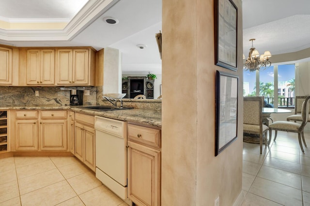 kitchen featuring crown molding, an inviting chandelier, a tray ceiling, dishwasher, and a sink