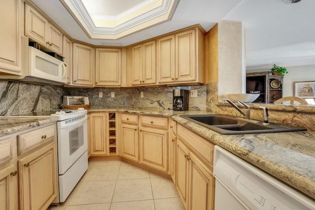 kitchen featuring crown molding, light tile patterned floors, white appliances, a sink, and a raised ceiling