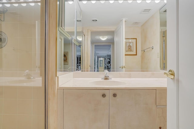 full bathroom with tiled shower, vanity, and visible vents