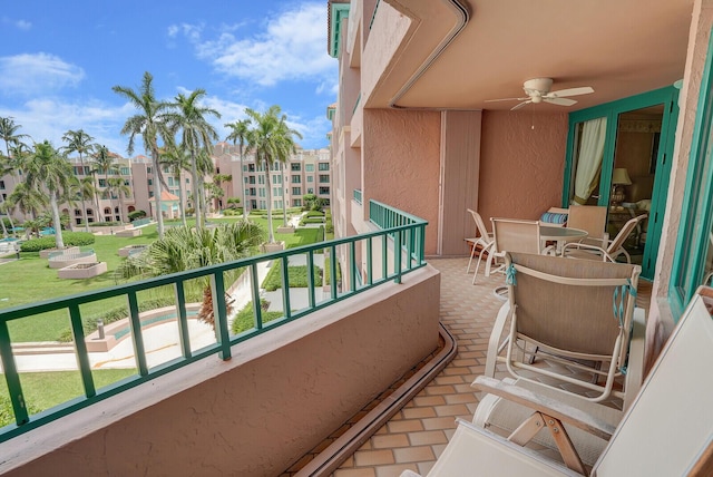 balcony featuring outdoor dining area and a ceiling fan
