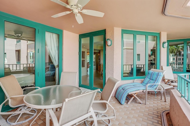 sunroom / solarium with outdoor dining area and ceiling fan