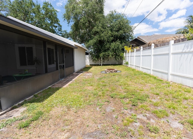 5740 Teakwood Rd, Lake Worth, FL 33467 - view of yard featuring a fire pit, a fenced backyard, and a sunroom