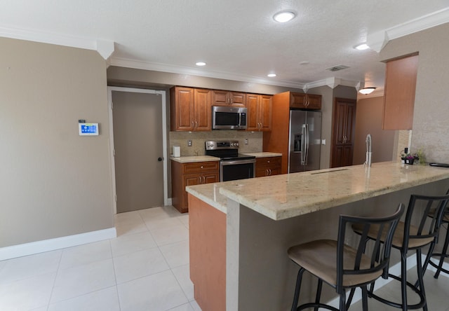 5740 Teakwood Rd, Lake Worth, FL 33467 - kitchen featuring a peninsula, visible vents, ornamental molding, and appliances with stainless steel finishes