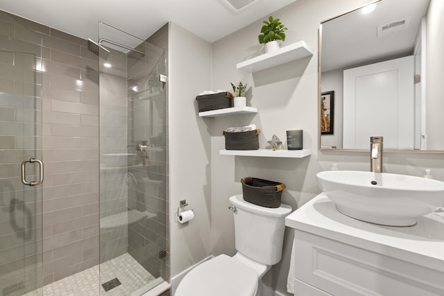 bathroom with toilet, vanity, visible vents, and a stall shower