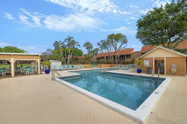 community pool featuring a patio, an outbuilding, and fence