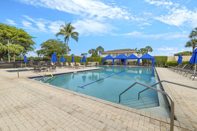 pool with a patio and fence