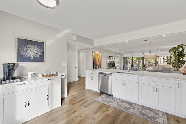 kitchen featuring visible vents, dishwasher, a sink, open floor plan, and white cabinetry