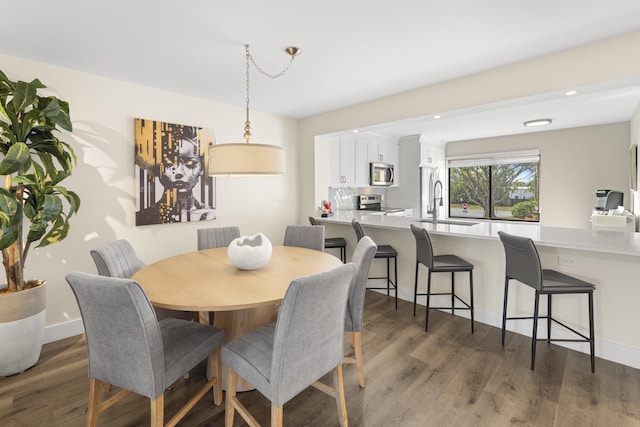 dining area featuring recessed lighting, baseboards, and wood finished floors