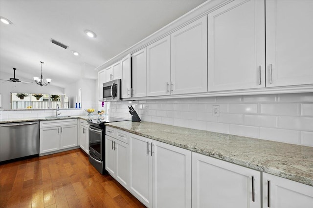 kitchen with decorative backsplash, a sink, white cabinets, and stainless steel appliances