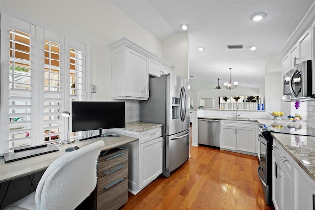 kitchen with a wealth of natural light, tasteful backsplash, a sink, and appliances with stainless steel finishes