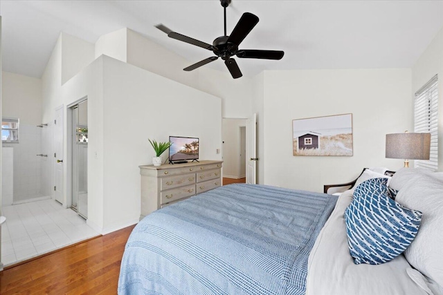 bedroom with a ceiling fan, connected bathroom, and wood finished floors