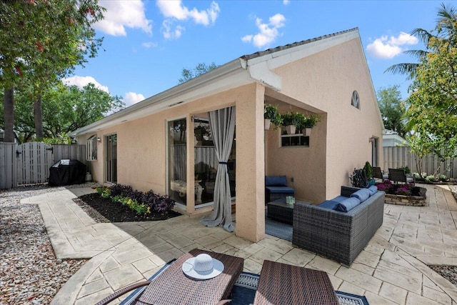 exterior space with an outdoor living space, grilling area, fence, and a gate