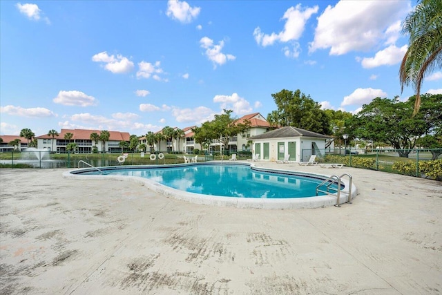 pool with a patio and fence