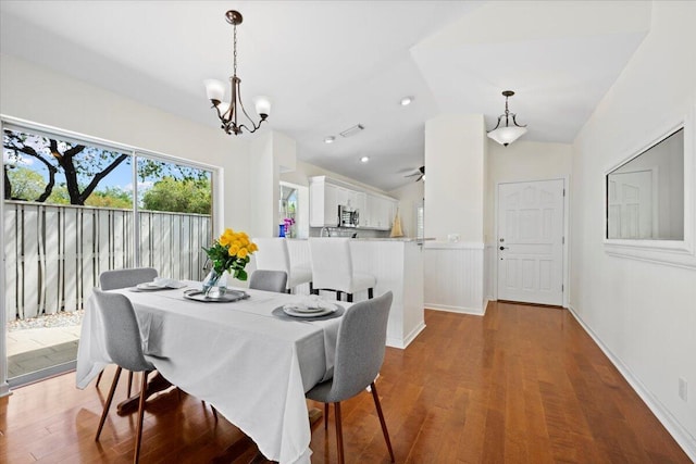 dining space with wood finished floors, an inviting chandelier, and lofted ceiling