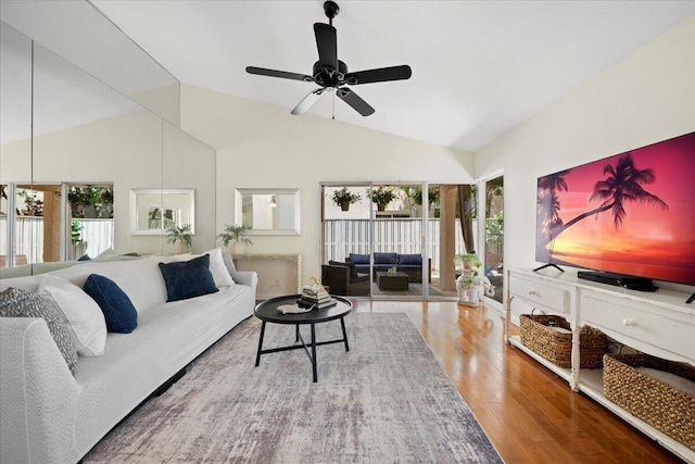 living area with wood finished floors, a ceiling fan, and lofted ceiling