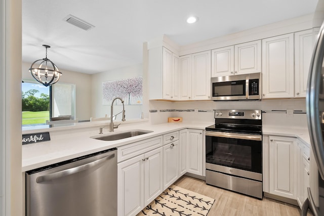 5657 SE Foxcross Pl, Stuart, FL 34997 - kitchen with stainless steel appliances, a sink, light countertops, decorative backsplash, and recessed lighting