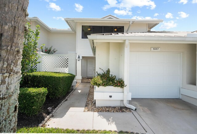 5657 SE Foxcross Pl, Stuart, FL 34997 - doorway to property featuring a garage, driveway, and stucco siding