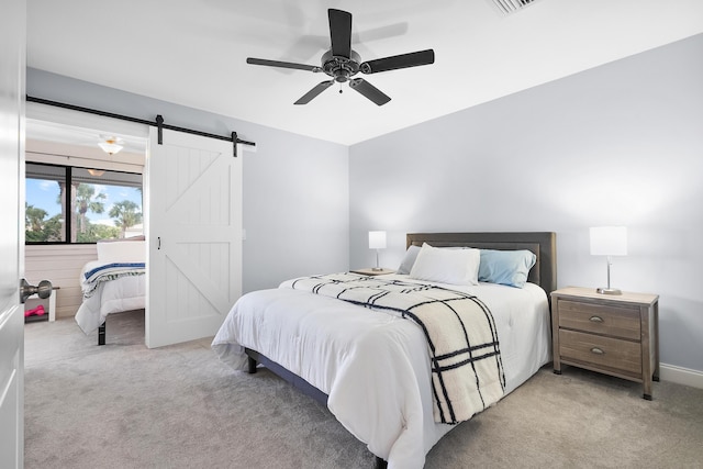 5657 SE Foxcross Pl, Stuart, FL 34997 - bedroom with a barn door, light carpet, and ceiling fan