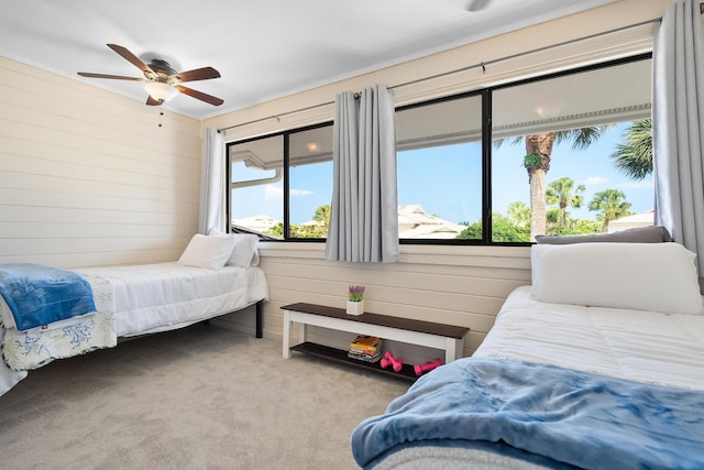 5657 SE Foxcross Pl, Stuart, FL 34997 - bedroom featuring carpet, wood walls, and ceiling fan