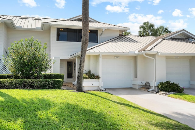 5657 SE Foxcross Pl, Stuart, FL 34997 - view of property featuring a standing seam roof, metal roof, an attached garage, and a front lawn