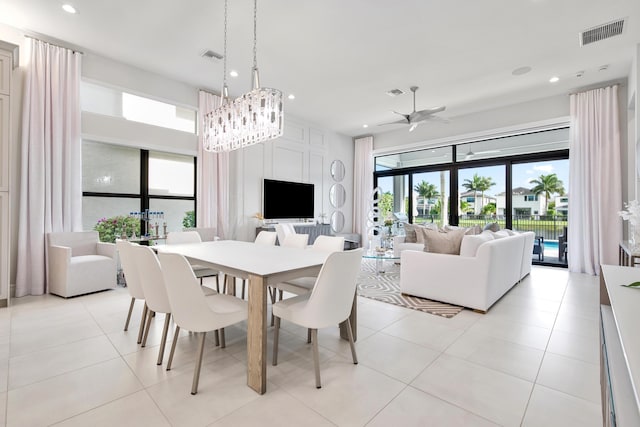 dining room featuring a healthy amount of sunlight, ceiling fan with notable chandelier, visible vents, and recessed lighting
