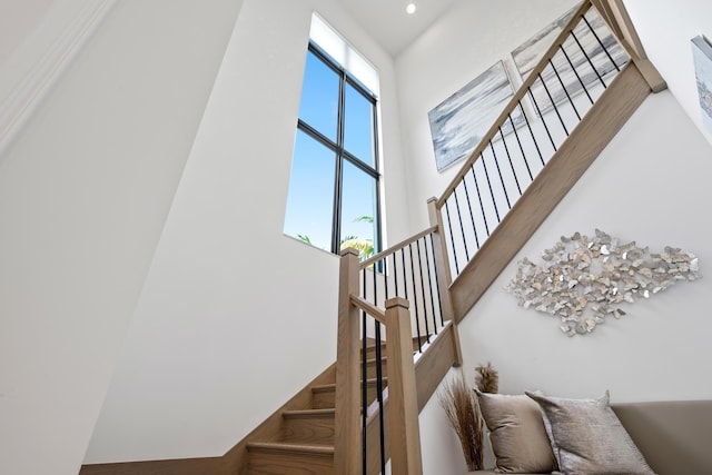 stairway featuring a high ceiling and recessed lighting