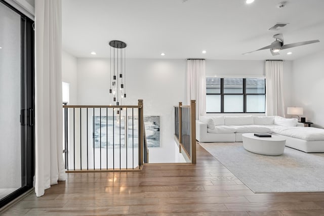 living area featuring recessed lighting, visible vents, and wood finished floors