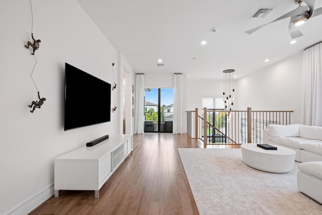 living area with light wood finished floors, baseboards, visible vents, and recessed lighting