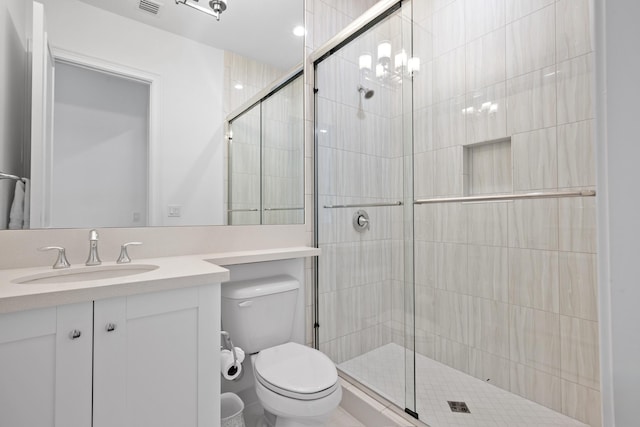 full bath with a shower stall, vanity, visible vents, and toilet