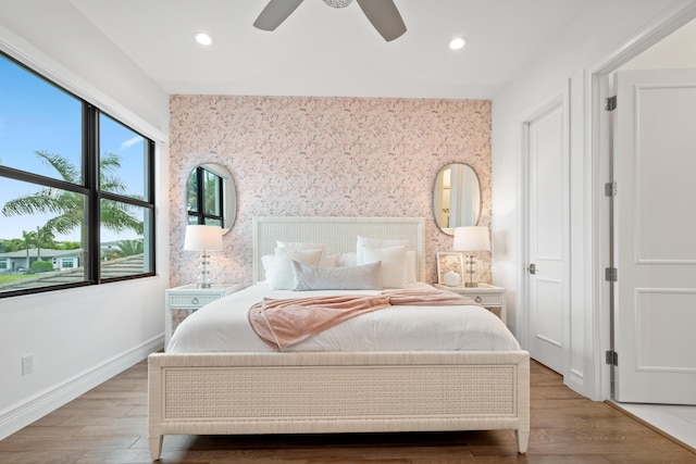 bedroom featuring recessed lighting, baseboards, wallpapered walls, and wood finished floors