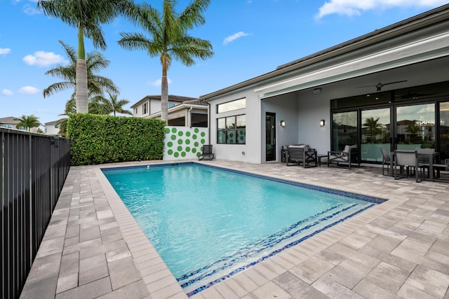 view of pool with a fenced in pool, a patio area, a fenced backyard, and a ceiling fan